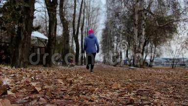 寒冷的阴天，女孩在秋天的公园里<strong>跑步</strong>。 在<strong>户外运动</strong>的妇女